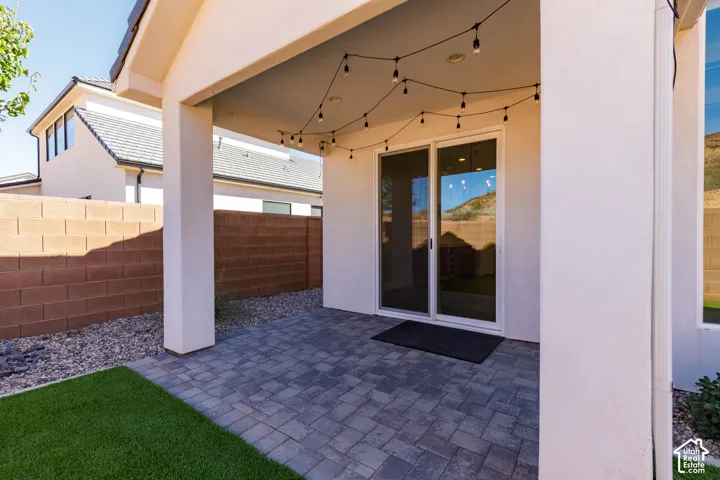 Covered patio with string lighting and multiple support columns, seamlessly integrated with the home's modern architecture