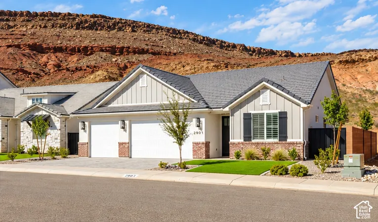 Modern stucco exterior with brick accents, composite shingle roofing, and a two-car garage