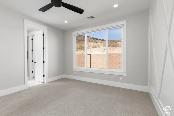 Recessed ceiling lighting, a modern ceiling fan, large windows, and decorative wall paneling