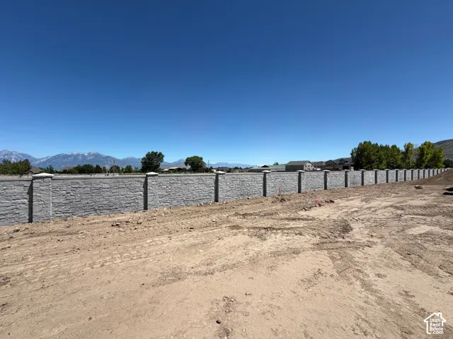 Extensive stone-finish retaining wall with decorative pillar accents