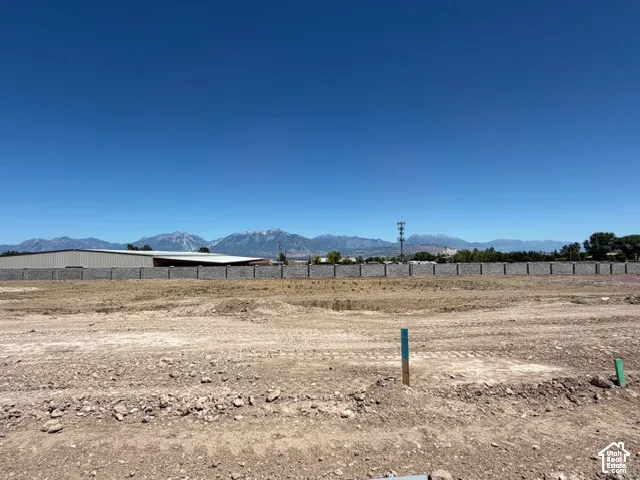 Expansive cleared lot with a privacy fence, offering a mountainous backdrop