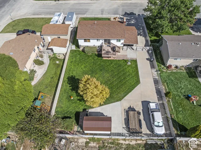 Expansive lawn with mature trees and paved driveway