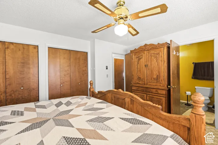 Ceiling fan with integrated lighting, wood-finish bi-fold closet doors, and painted interior walls