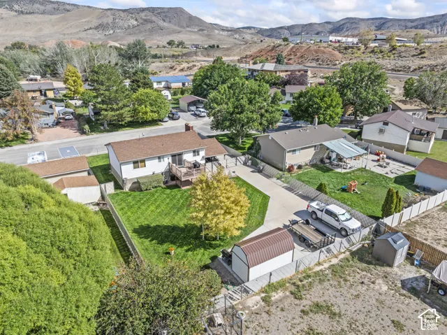 Expansive lot with a detached shed, paved driveway, mature landscaping, and a multi-level wood deck