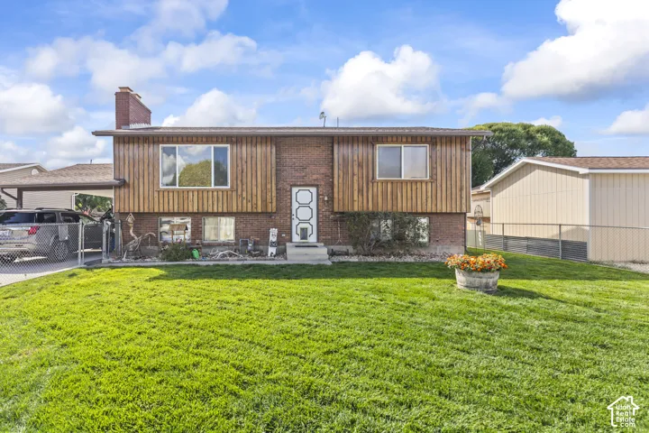 Brick and wood-paneled exterior with a front lawn