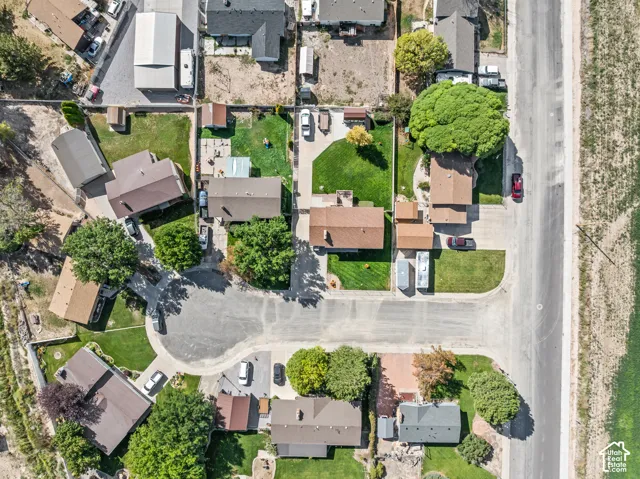 Aerial perspective showcasing residential properties with pitched roofs, surrounded by mature trees and landscaped grounds