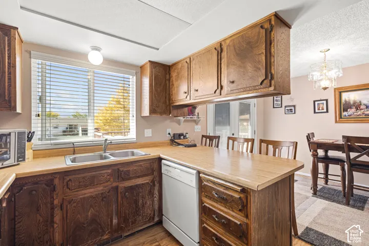 Kitchen featuring wood cabinetry, a double basin sink, and white appliances