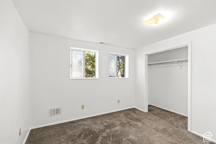 Wall-to-wall carpeting, dual windows, and an open closet with built-in shelving