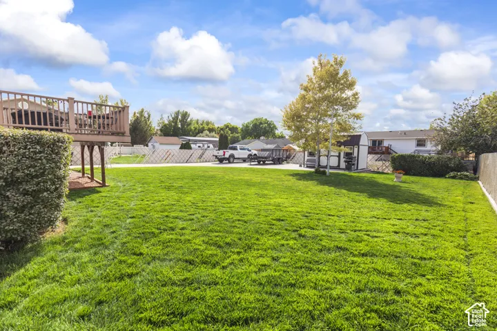 Expansive lawn, mature landscaping, wood deck, privacy fencing, storage shed