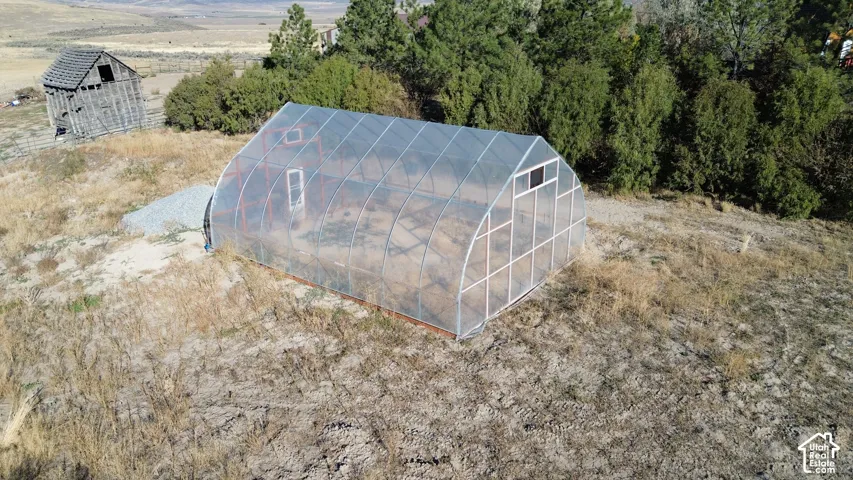 Arched greenhouse structure with translucent panels and a vent window