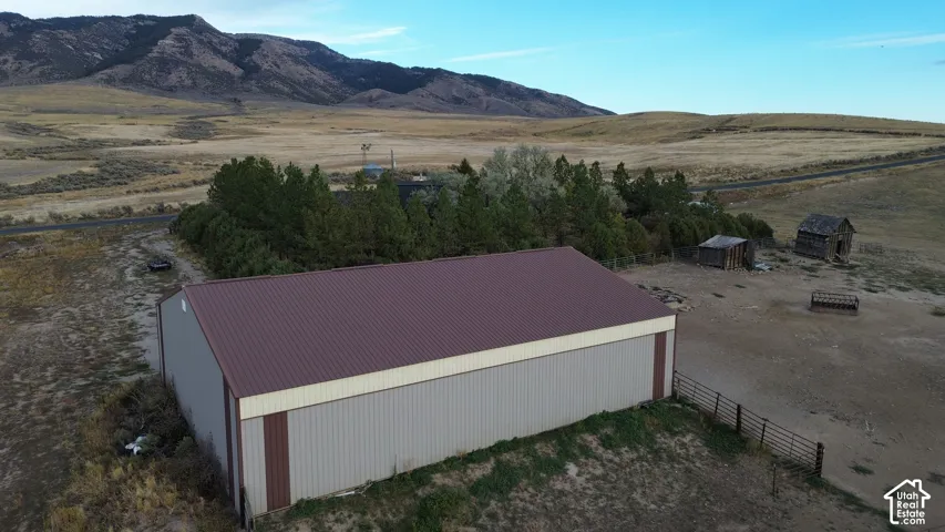 Metal-sided outbuilding with a brown roof and light-colored siding, featuring a brown vertical trim accent
