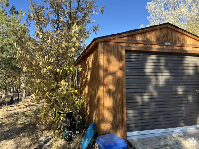 Wood-sided outbuilding with a roll-up garage door and a side window