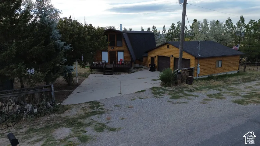 A-frame style residence with a wood-clad exterior, covered front porch, and an attached two-car garage