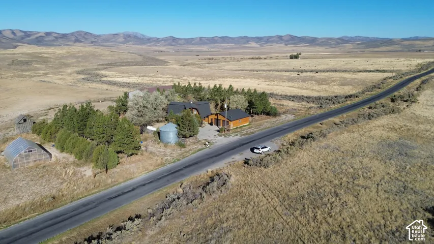 Log home with a dark roof and a paved road frontage