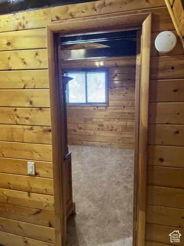Wood-paneled room featuring a window and carpeting