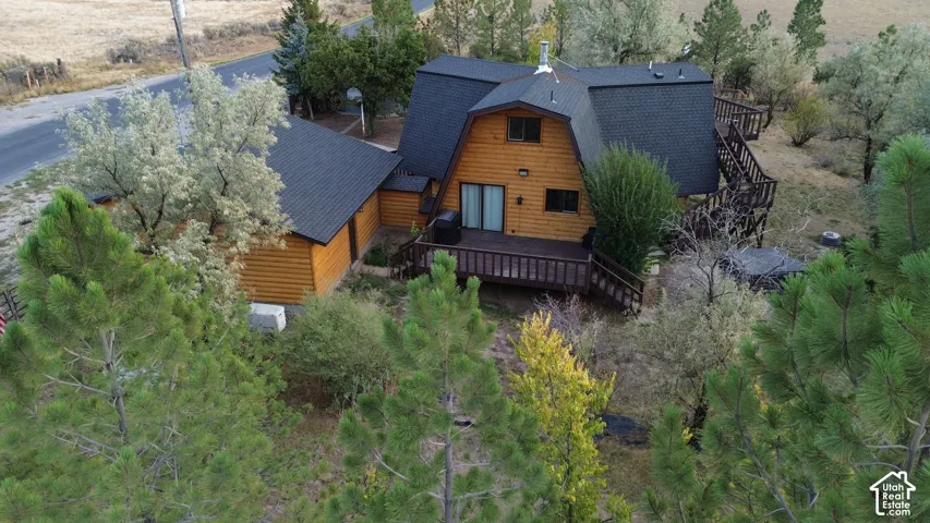 Wood siding exterior with a dark shingled roof, featuring multiple decks and mature trees