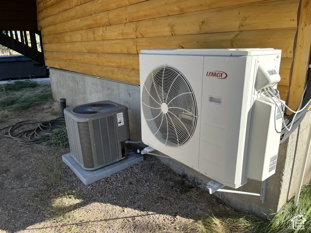 Wall-mounted Lennox heat pump, a ground-level air conditioning unit, and a log-style exterior