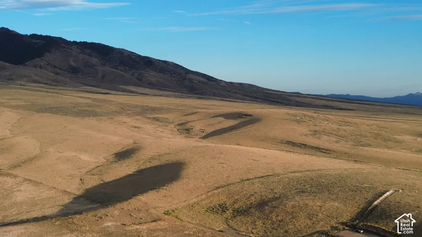 Expansive land parcel featuring natural terrain and distant mountain ranges
