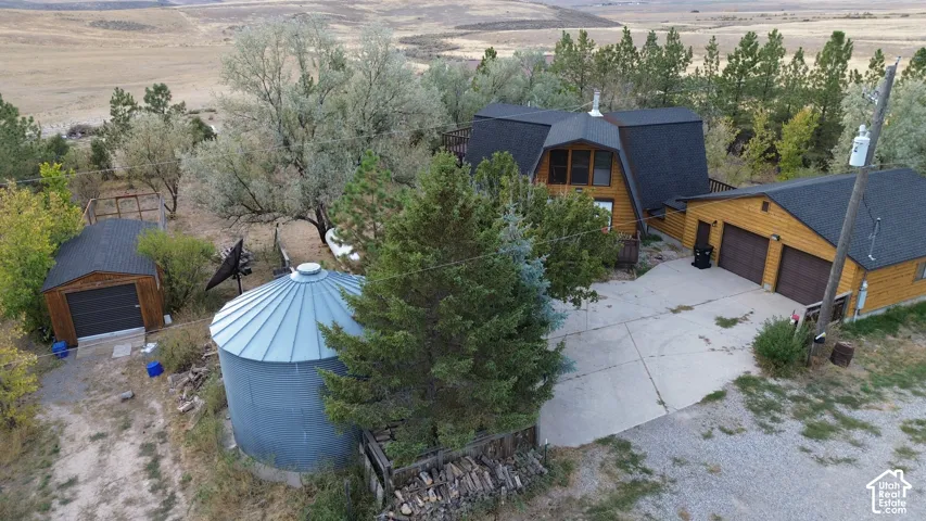 Barn-style architecture with wood siding, two-car garage, separate detached garage, and a large metal storage silo