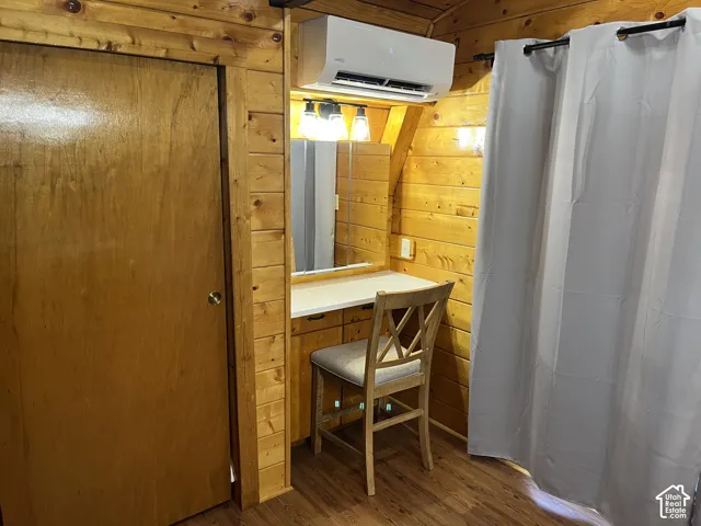 Wood-finish wall paneling, built-in vanity with mirror, and wall-mounted lighting