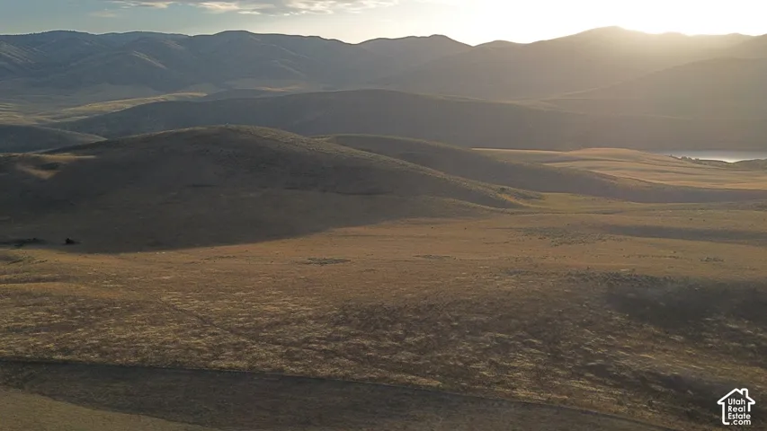 Expansive natural landscape featuring rolling hills and distant mountains