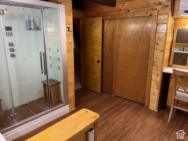 Shower enclosure with multiple jets and wood-finish flooring