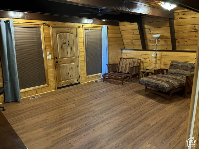 Wood-finish flooring, paneled wood walls, and a wood-finish door with black hardware