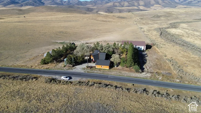 Mountainous terrain, rural setting, detached garage, mature trees, paved road