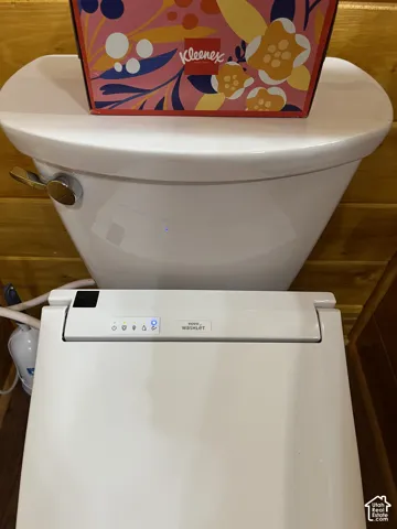 White porcelain toilet with a chrome flush lever and integrated bidet system