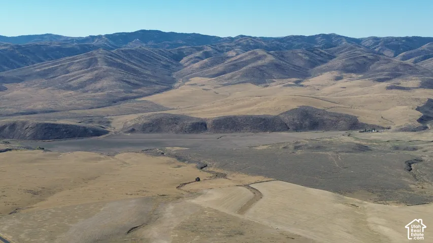 Expansive land parcel featuring rolling hills, distant mountain ranges, and natural terrain