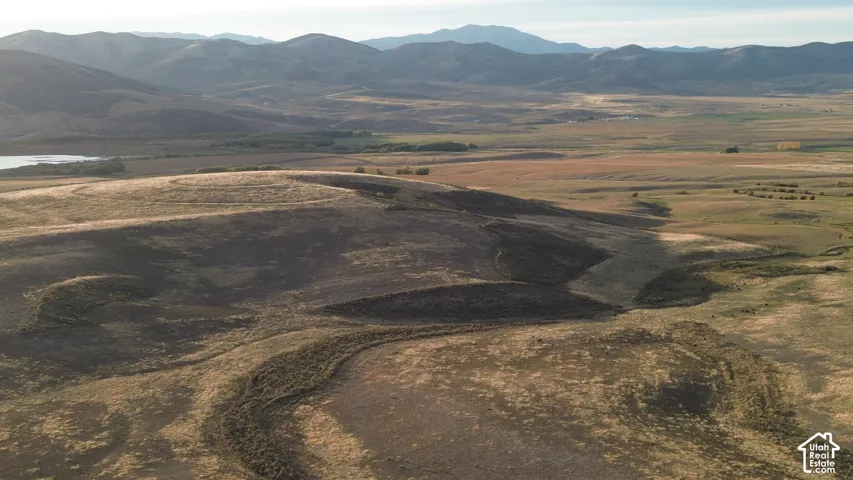 Expansive landscape featuring rolling hills, varied terrain, and distant mountains