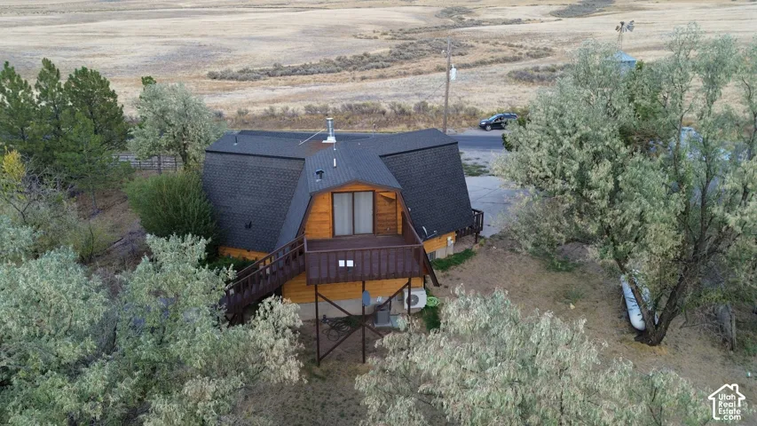 Wood siding with a gambrel roof and dark shingles