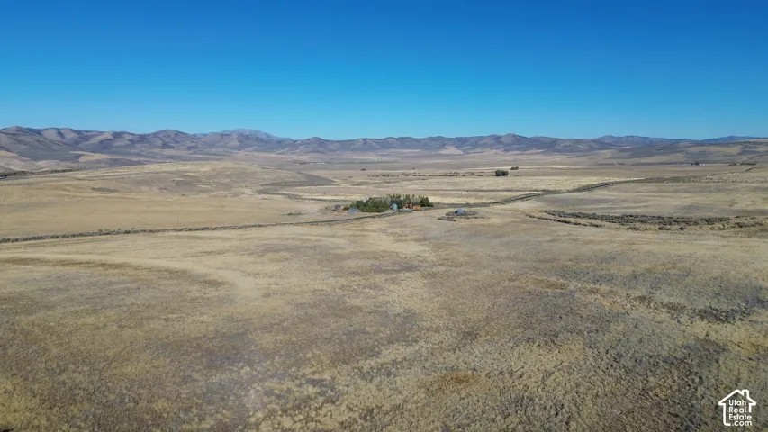 Expansive undeveloped land with a distant structure and mountainous background