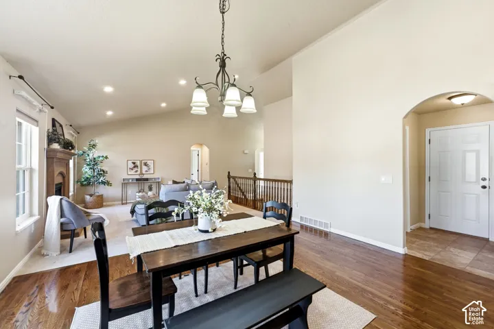 Hardwood flooring, vaulted ceilings, recessed lighting, arched doorway, and built-in fireplace with wood mantel