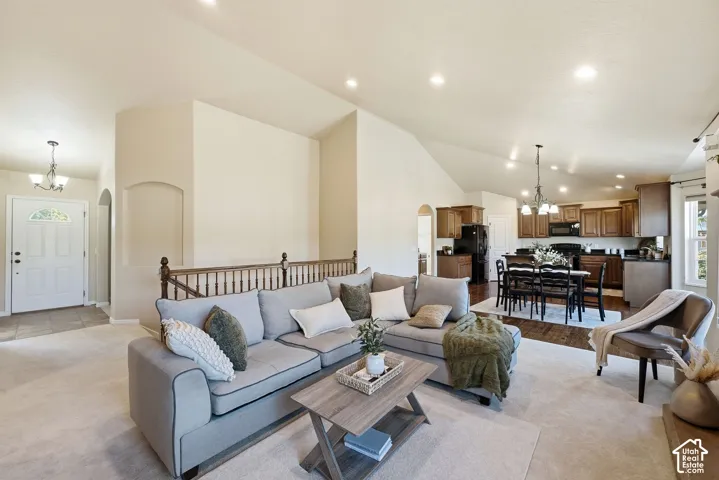 Open-concept living space featuring vaulted ceilings, recessed lighting, and a kitchen with dark wood cabinetry