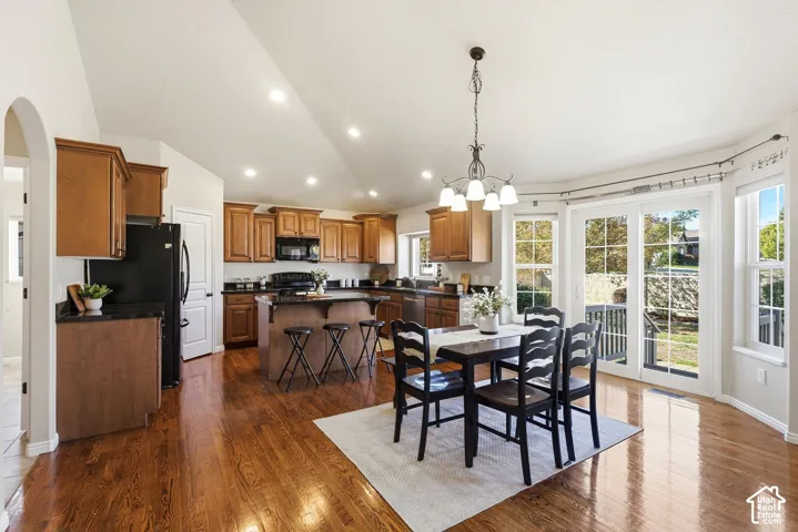 Open-concept kitchen and dining area featuring wood-finish flooring, recessed lighting, and a kitchen island with seating