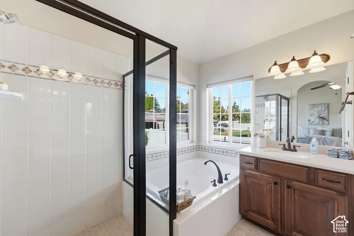 Walk-in shower with tiled walls and glass enclosure, adjacent to a soaking tub