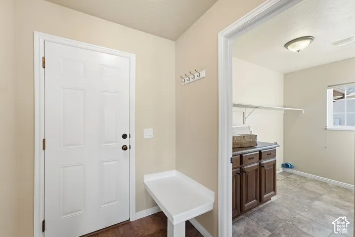 White paneled door with dark hardware, built-in white bench, and wall-mounted coat rack
