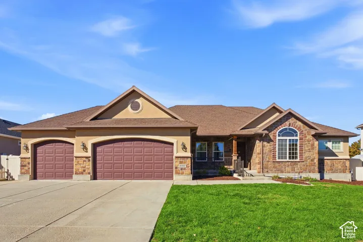 Stone and stucco exterior with a prominent arched window and a covered front entry