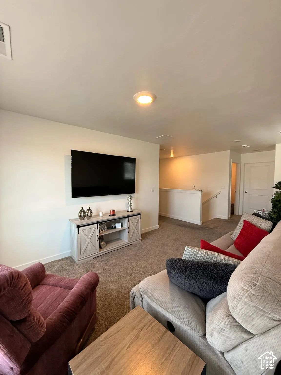 Carpeted living area featuring recessed lighting, a media console, and a wall-mounted television