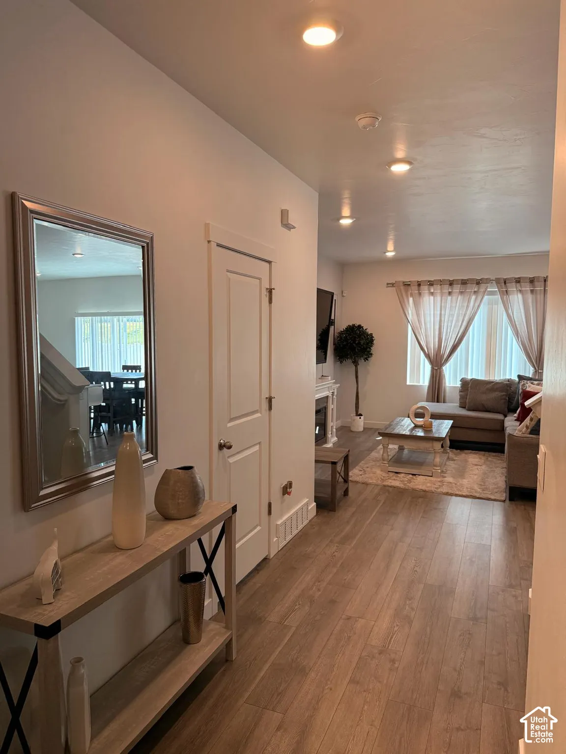 Wood-finish flooring throughout, recessed ceiling lighting, white interior doors, and a decorative fireplace with a mantel