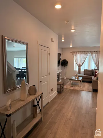 Wood-finish flooring throughout, recessed ceiling lighting, white interior doors, and a decorative fireplace with a mantel
