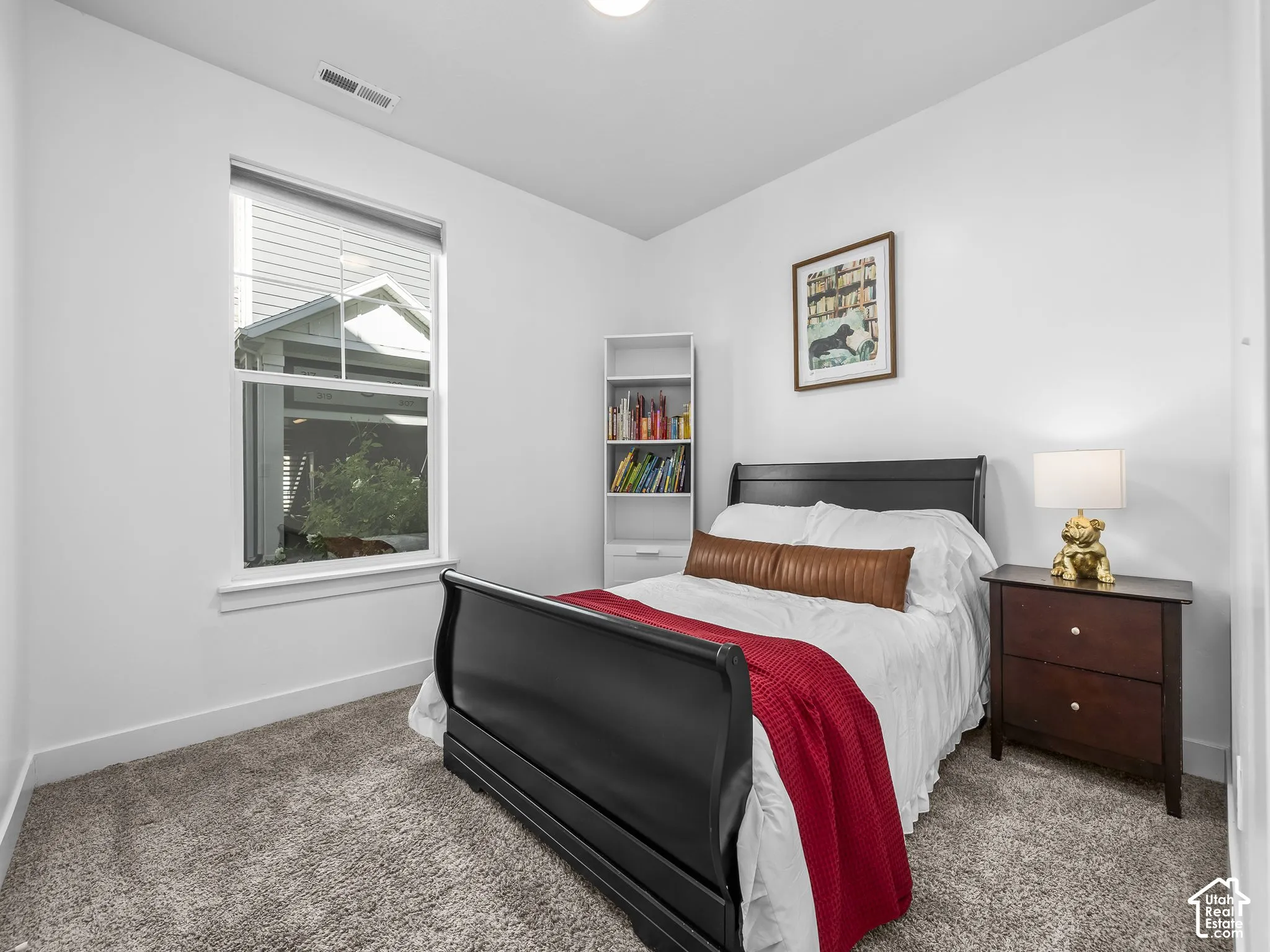 Recessed lighting, neutral paint, light gray carpeting, double-pane window, and a built-in bookshelf