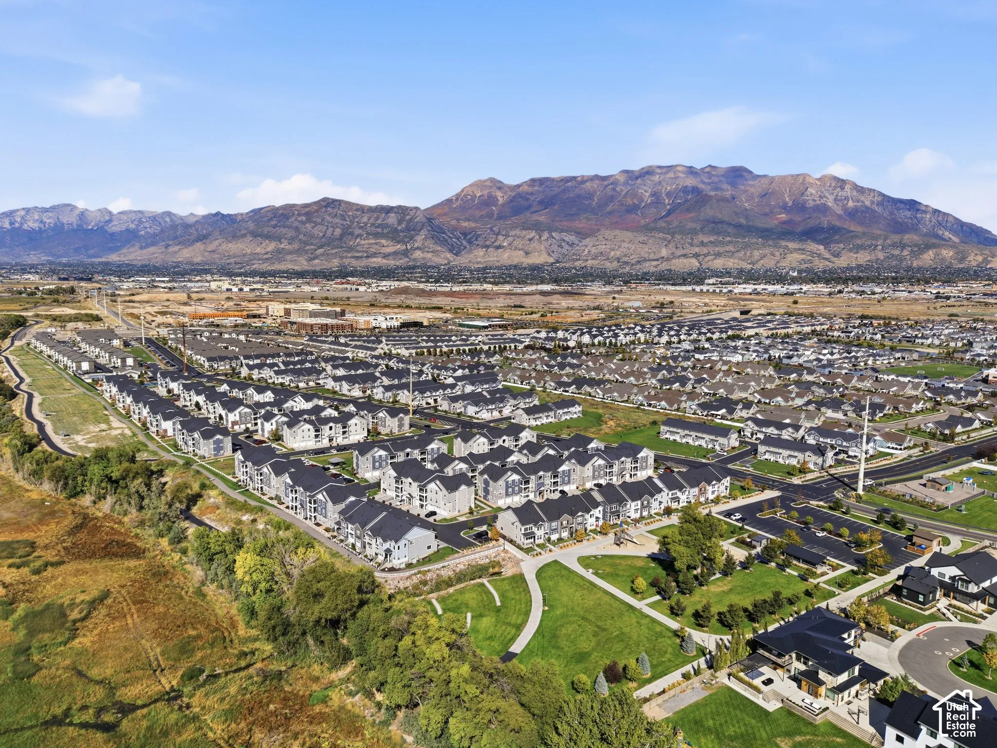 Expansive residential community with varied architectural styles, green spaces, and mountain backdrop