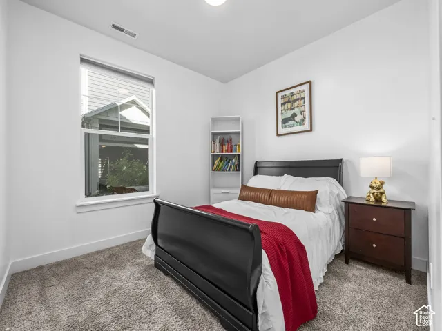 Recessed lighting, neutral paint, light gray carpeting, double-pane window, and a built-in bookshelf