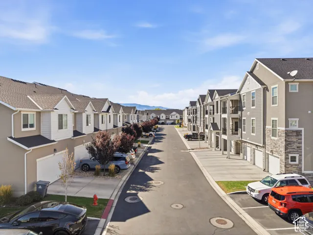 Row of multi-story residential buildings featuring gabled roofs and individual garages
