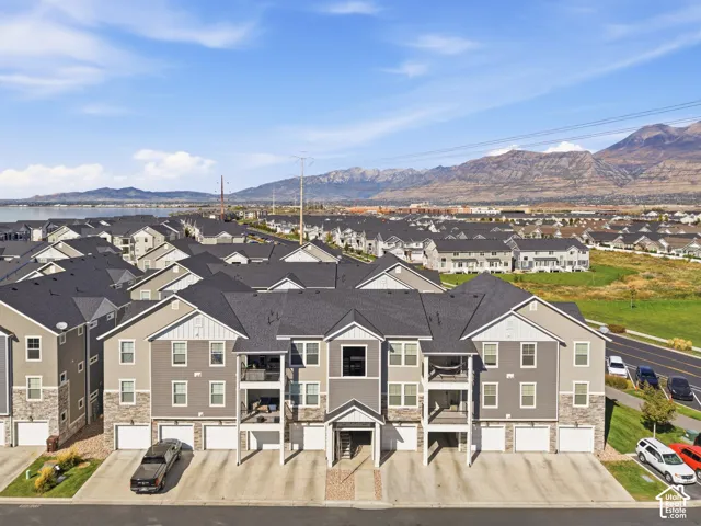 Multi-story residential complex featuring private balconies, attached garages, and stone-clad lower levels