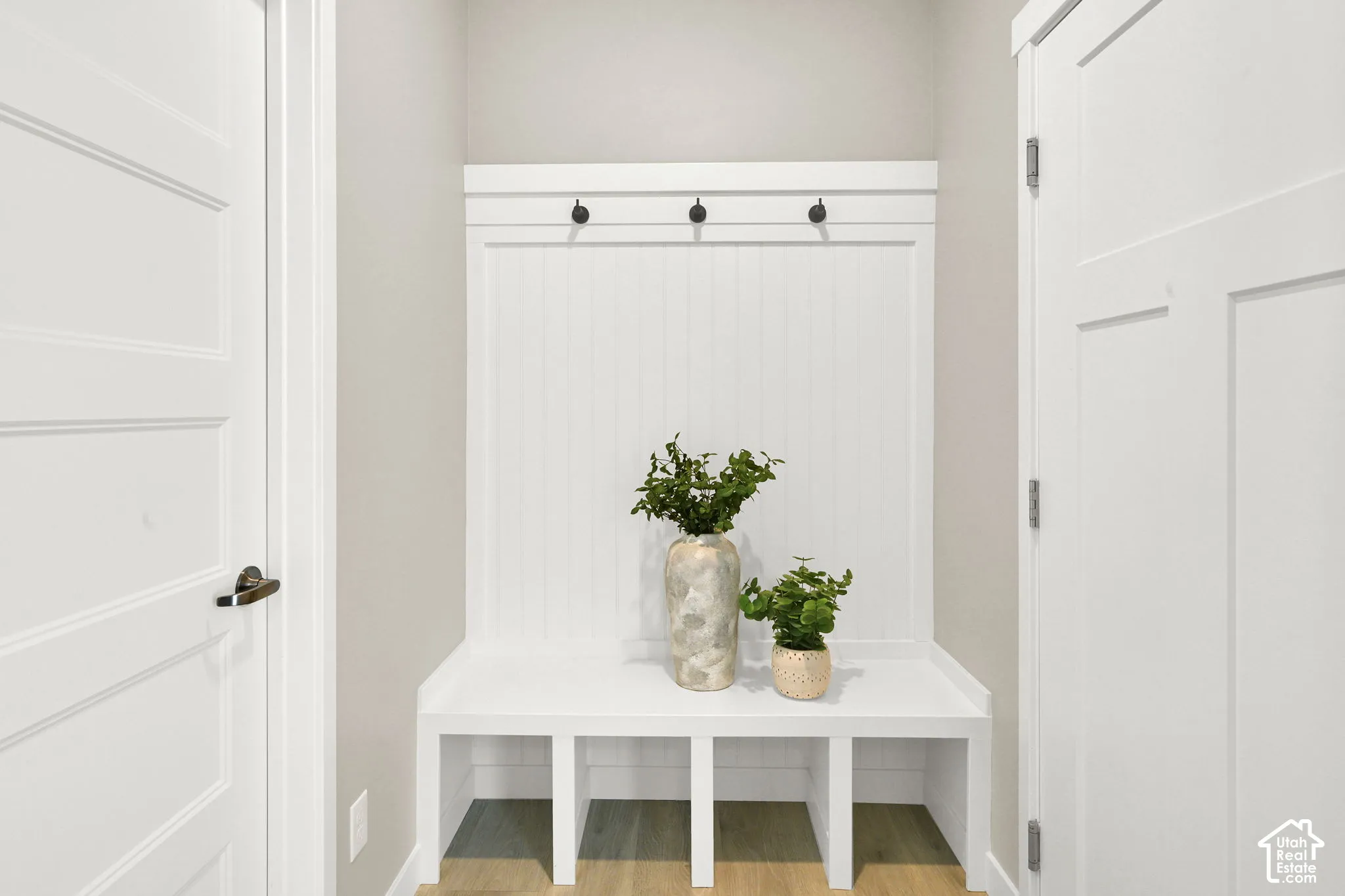 Built-in bench with cubby storage, beadboard paneling, and integrated coat hooks