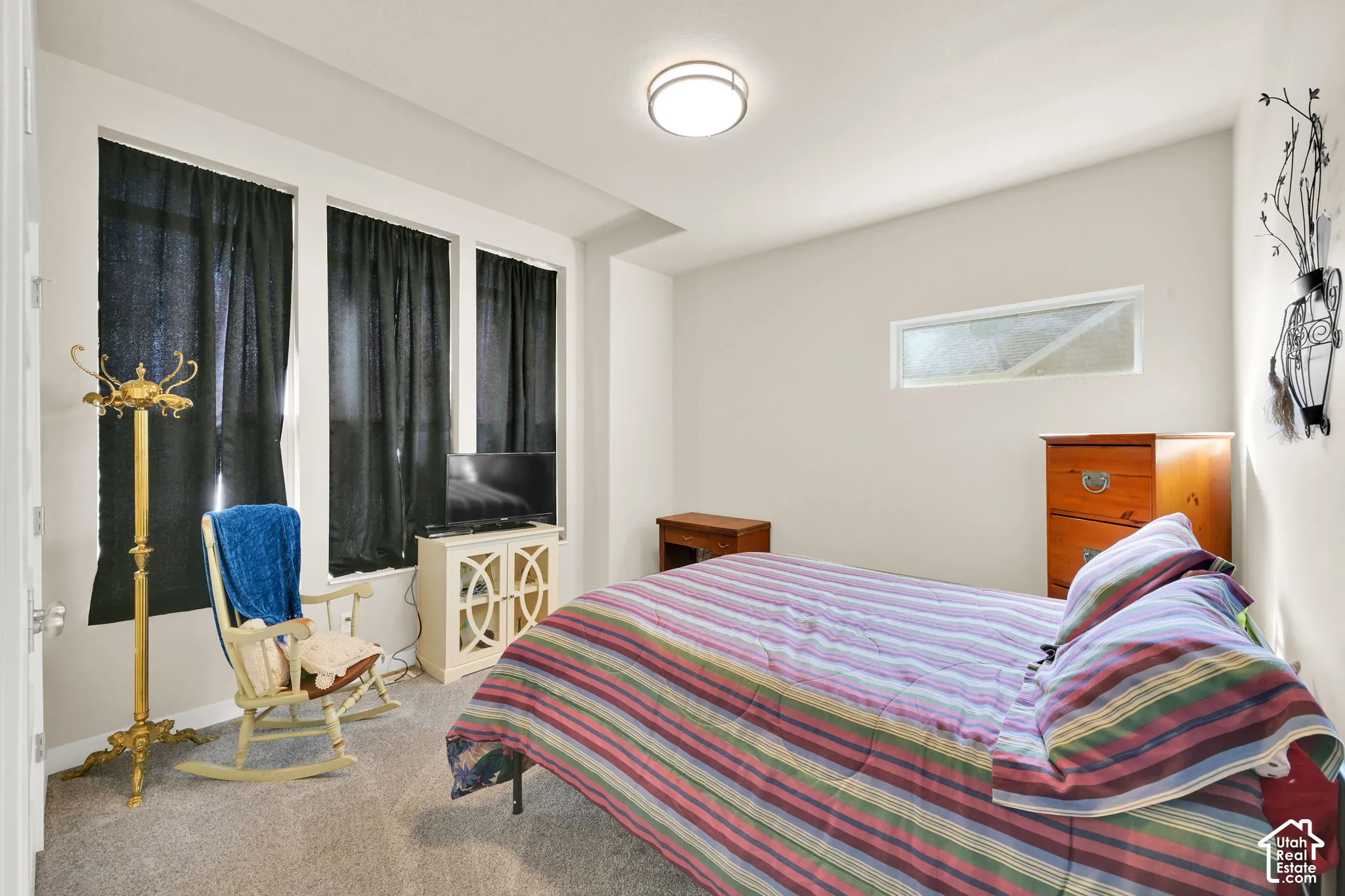 1st bedroom with light carpet and lots of windows