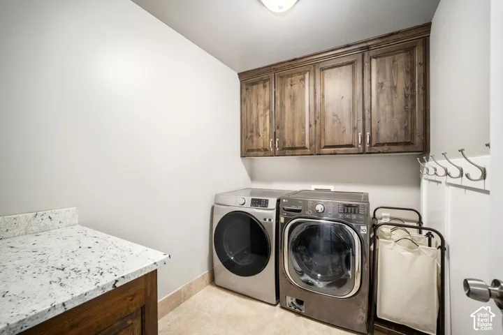 Laundry area featuring overhead wood cabinetry and a countertop with a speckled finish